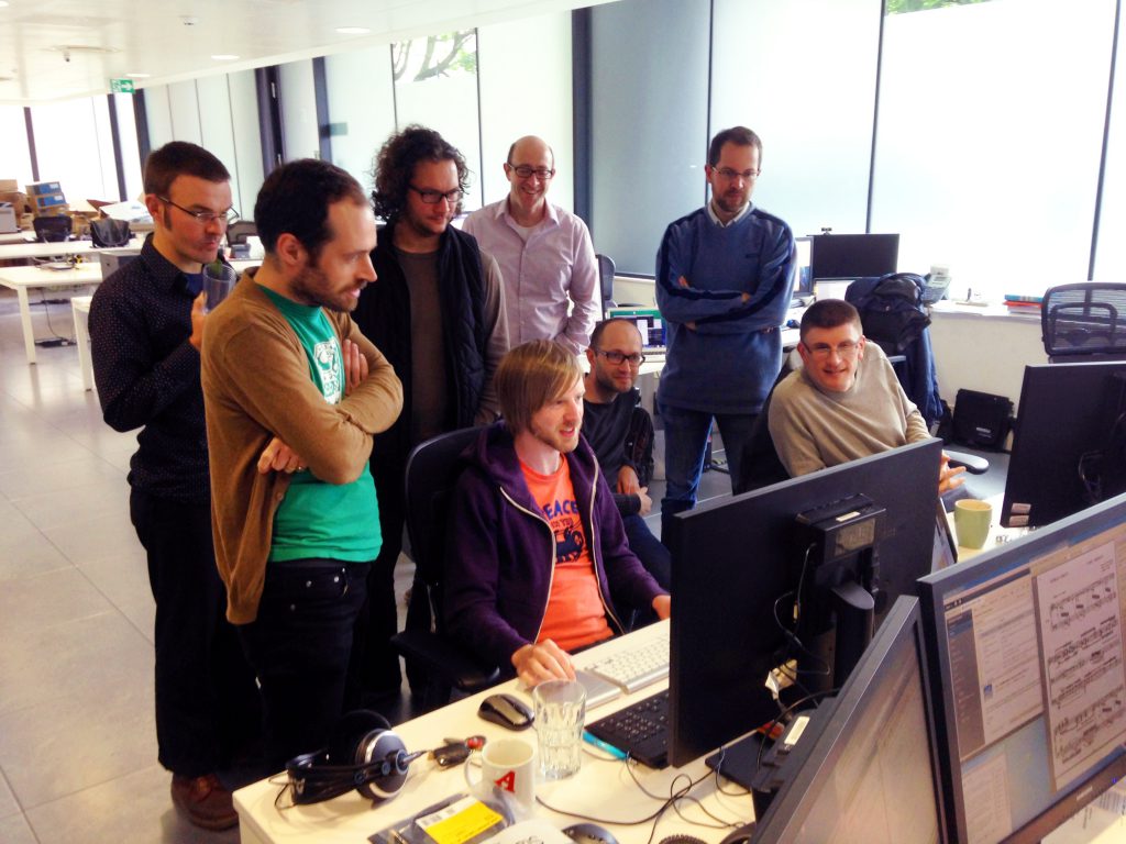 The team gathers round to watch the first edit be made.